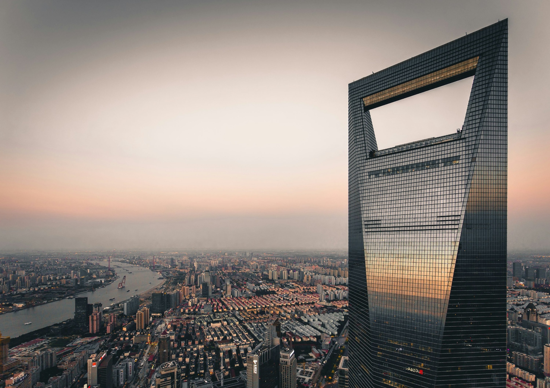Aerial view of Shanghai World Financial Center skyscraper at dusk over the city skyline
